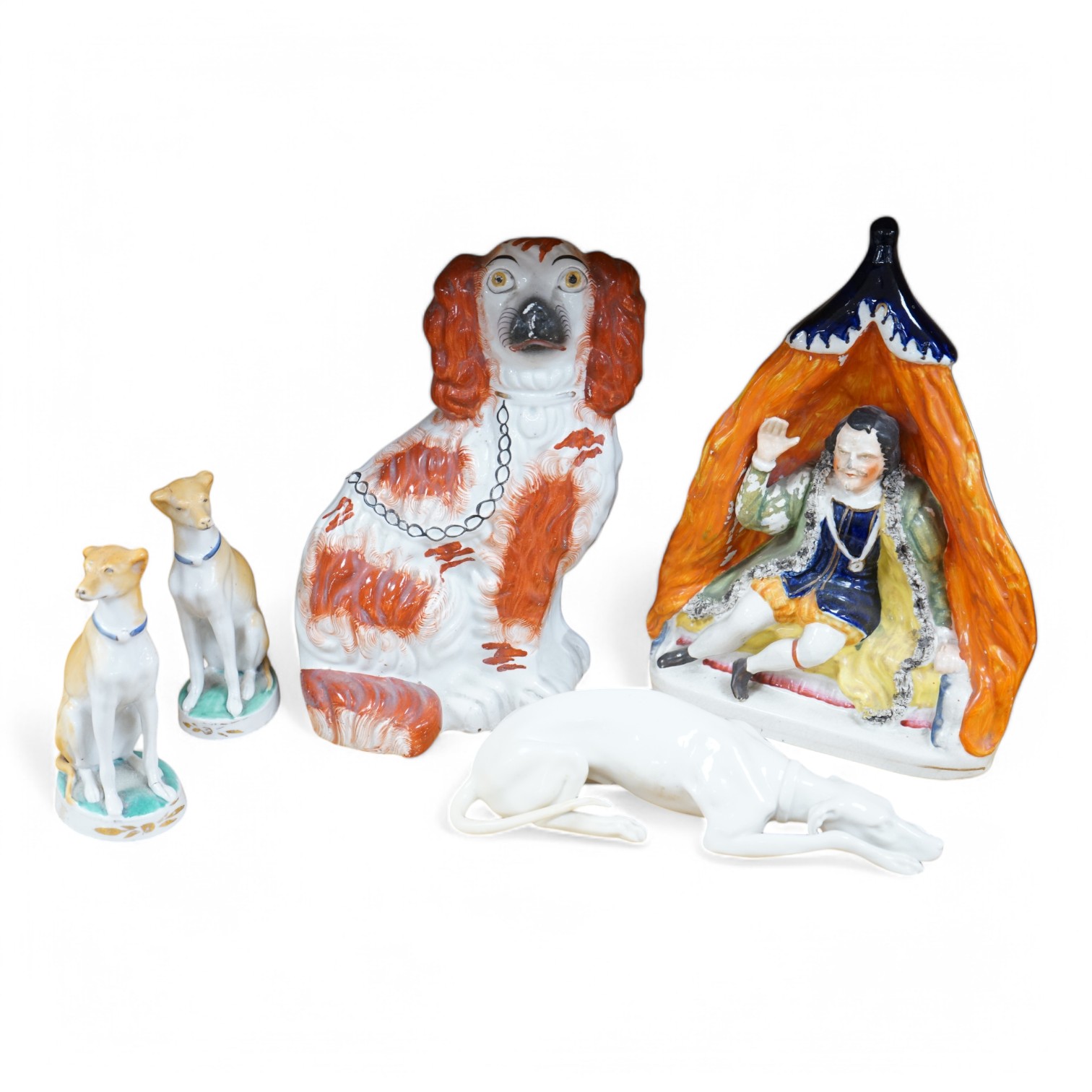 Four Victorian Staffordshire models, to include a pair of dogs, and a Nymphenburg whippet, largest 25cm high. Condition - fair/good